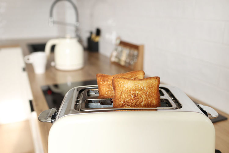 Toasted grain bread in white toaster, roasted sandwich toast, concept of healthy eating, dieting, 