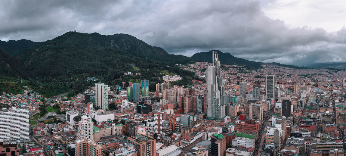 High angle view of city buildings against cloudy sky