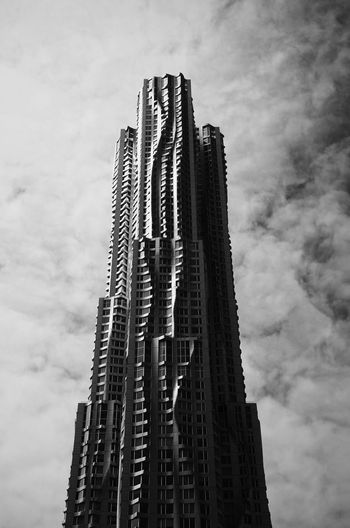 Low angle view of modern building against cloudy sky