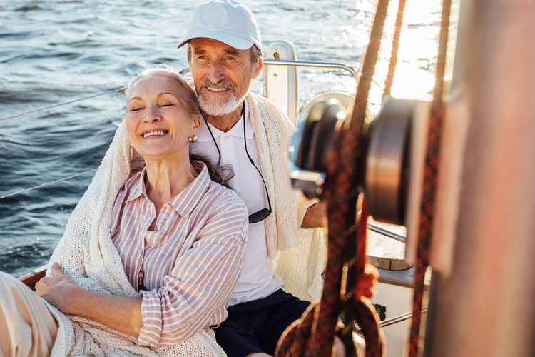 Smiling couple embracing while sitting in boat