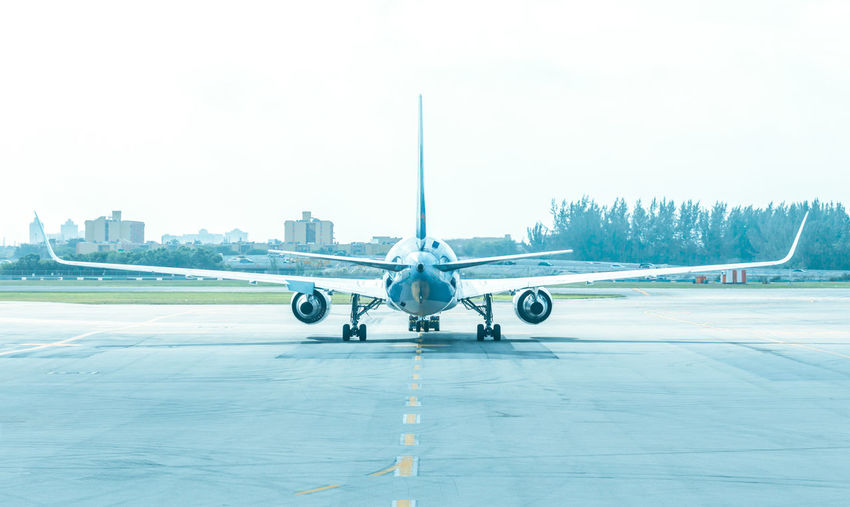 View of airplane at airport runway against sky