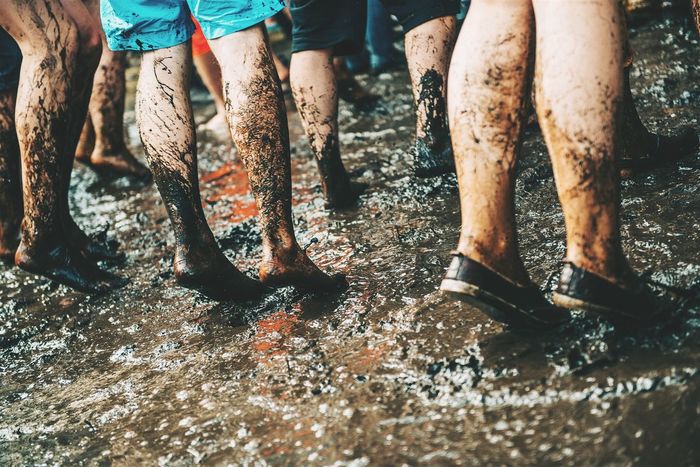 Low section of dirty legs dancing in mud