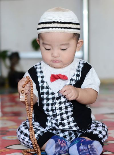 Full length of cute baby boy praying at home