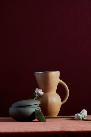 Handmade pottery and flowers on rich colored background