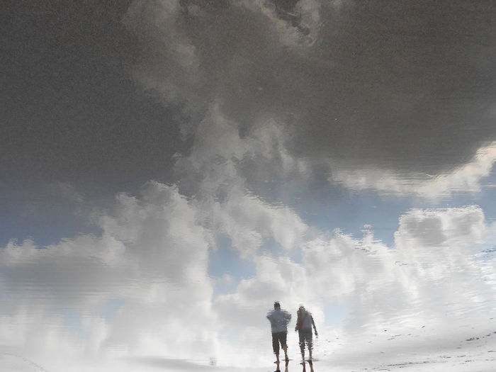 Reflection of clouds and people in water