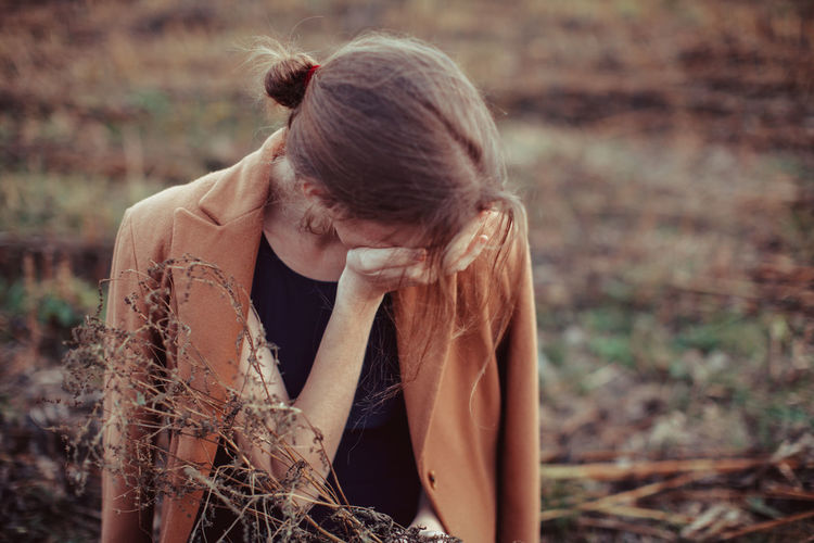Depressed woman standing on farm