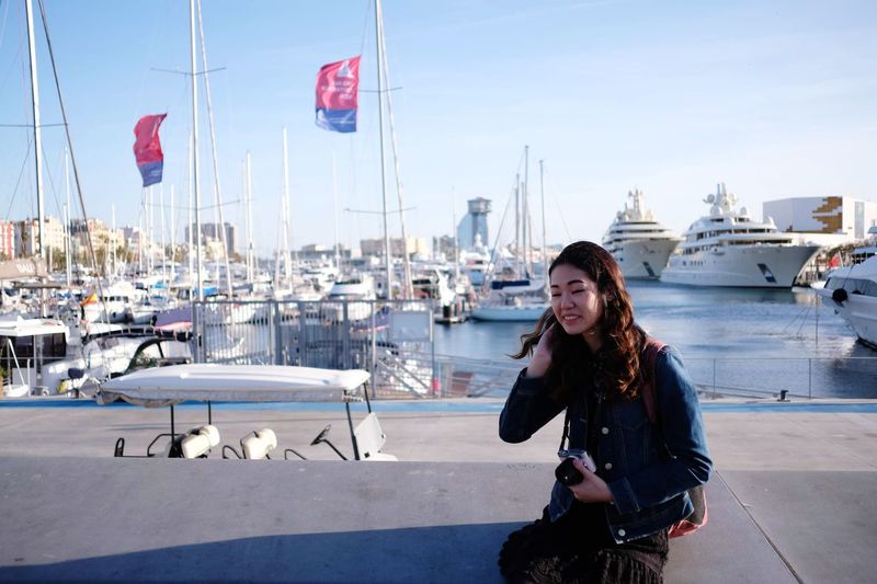 Young woman in harbor against sky