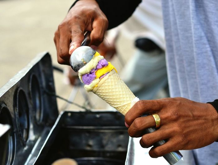 Close-up of vendor scooping ice cream to put in cone