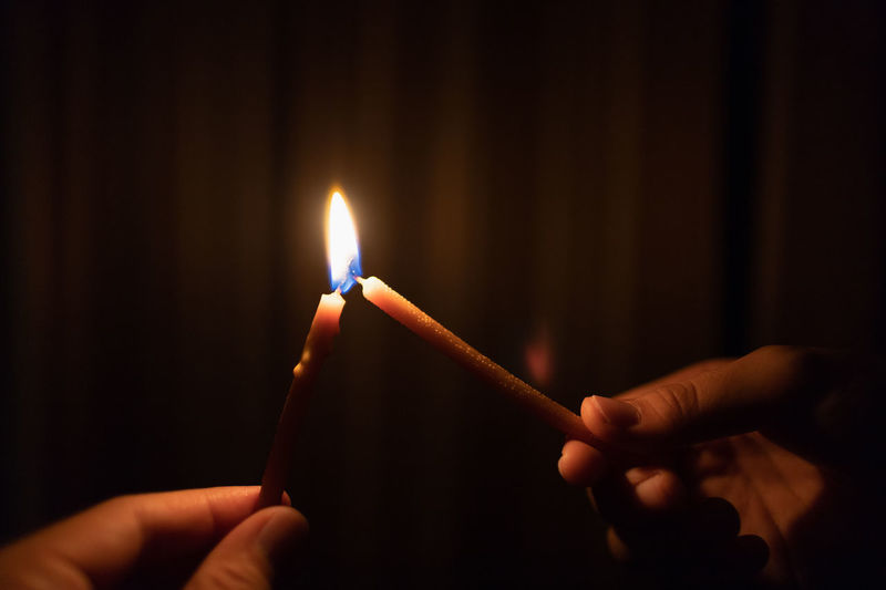 Close-up of people burning candles