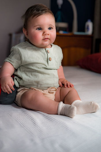 Sitting baby in vintage clothes for photo shoot
