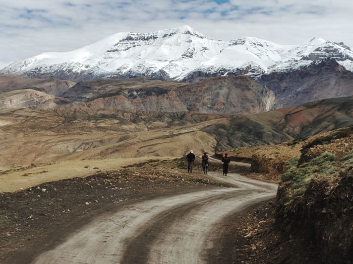 Three people trekking across mountains of spiti valley 