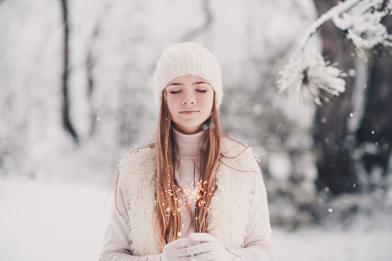 Teenager girl holding sparkler during winter