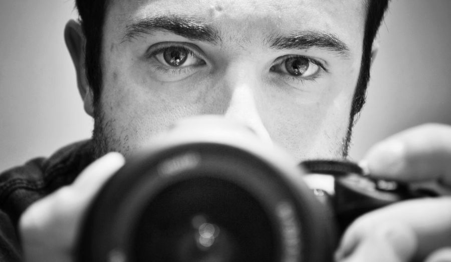 Close-up portrait of young man with camera