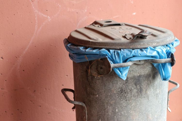 Close-up of garbage can against wall