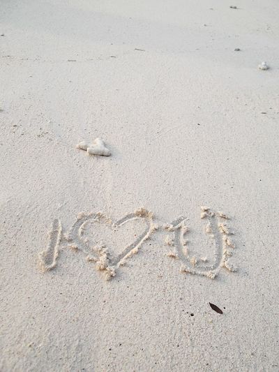 High angle view of heart shape with i love you text on beach