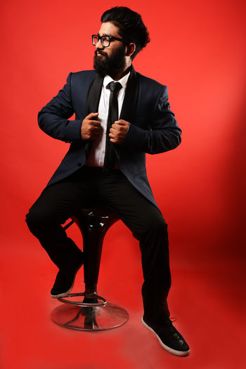 Full length of a young man over red background