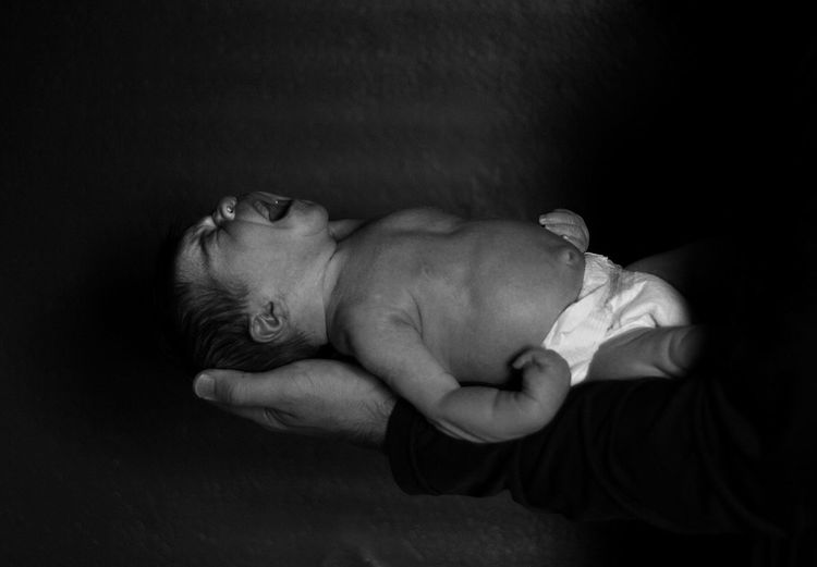 High angle view of baby sleeping against black background