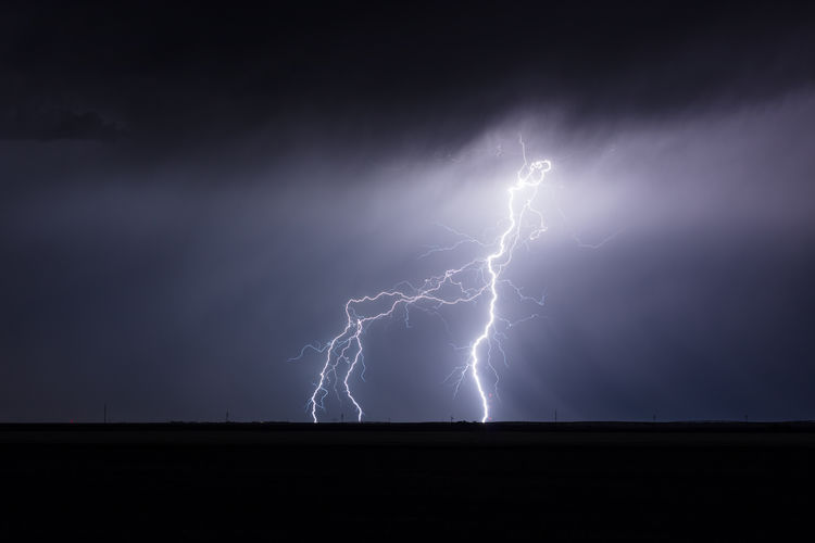 A dramatic cloud to ground lightning bolt strikes from a thunderstorm near colby, kansas