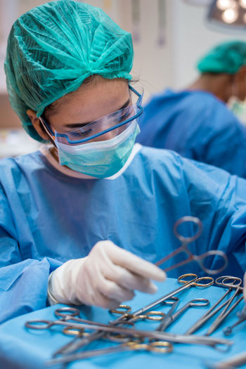 Doctor holding surgical equipment on table