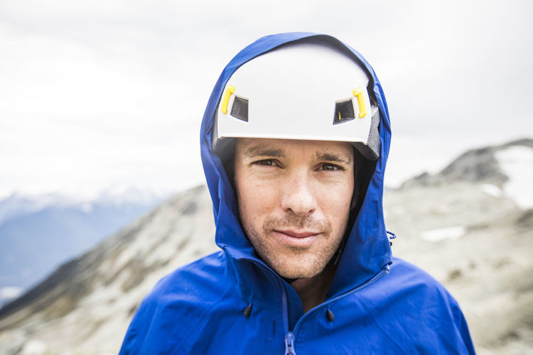 Portrait of mountain climber wearing helmet and rain jacket.