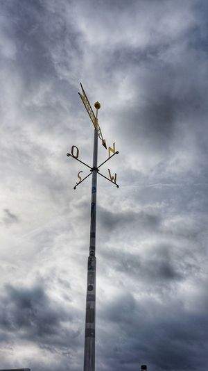 Low angle view of weathervane against sky