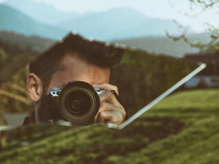 Man photographing from broken mirror