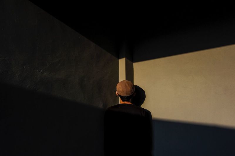 Rear view of man standing by wall