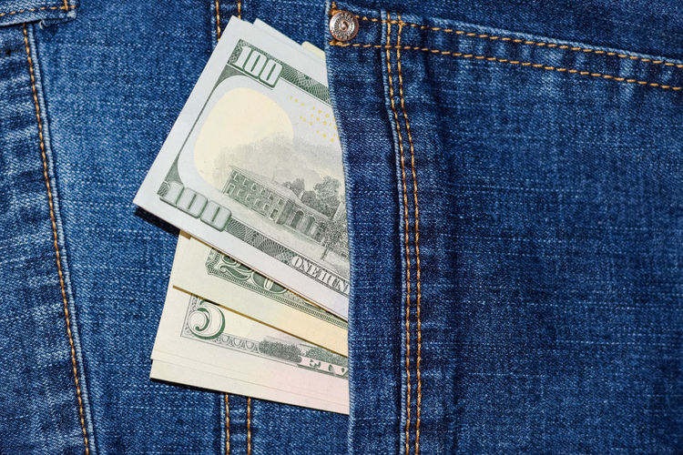 Close-up of paper currencies in jeans pocket
