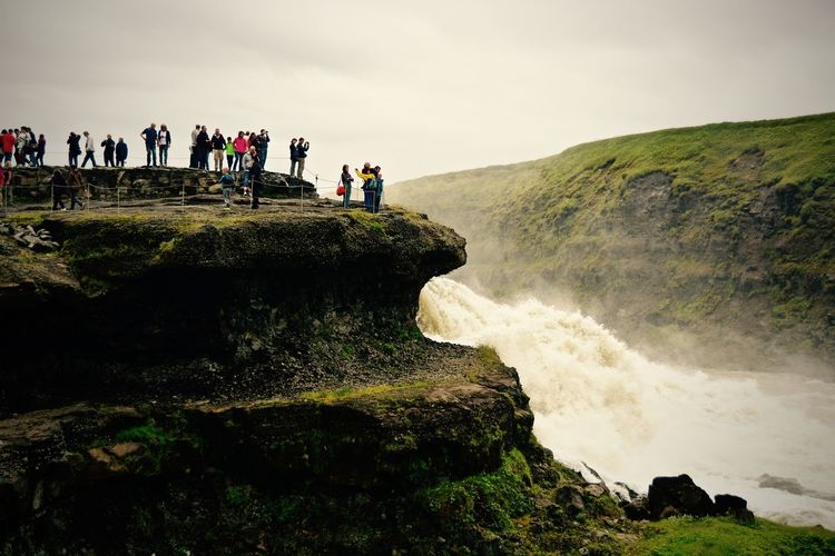 People at gullfoss falls against sky
