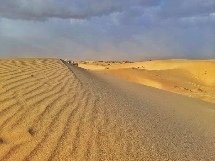 Sand dunes in desert with clouds sky before sandstorm