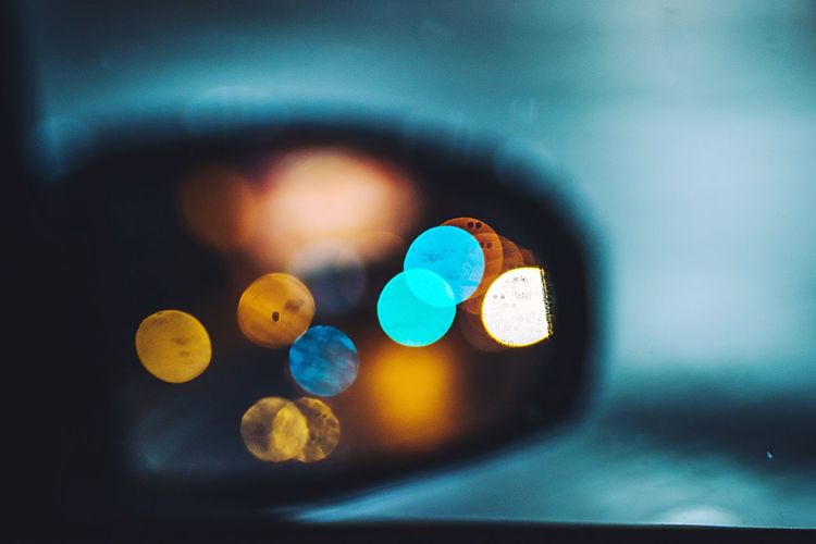 Defocused of illuminated lights seen in side-view mirror