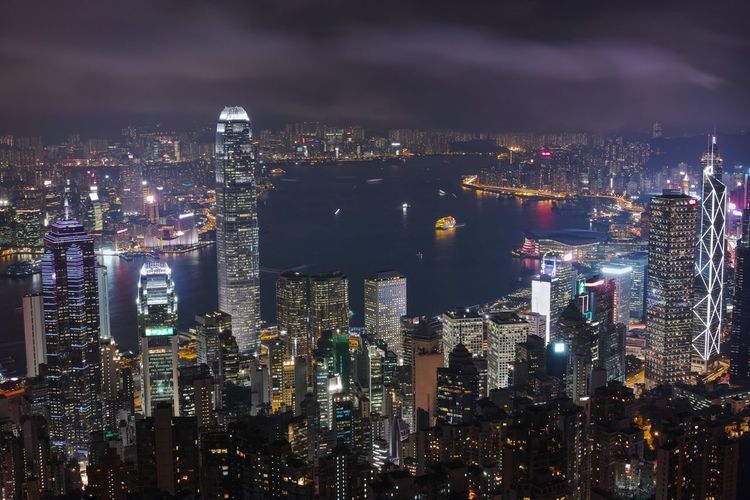 Illuminated modern buildings at victoria harbour during night