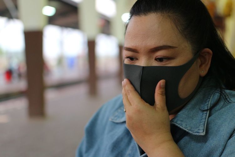 Close-up of woman wearing flu mask outdoors