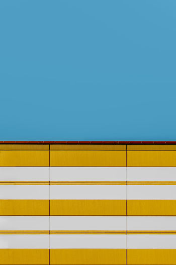 FULL FRAME SHOT OF YELLOW WALL AGAINST CLEAR SKY