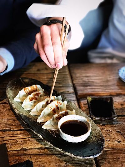 Close-up of woman eating dumplings on table