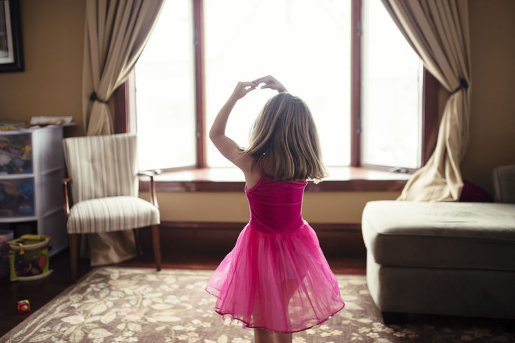 Rear view of girl dancing at home
