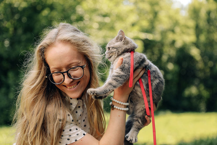 Happy girl with a scottish kitten in the park