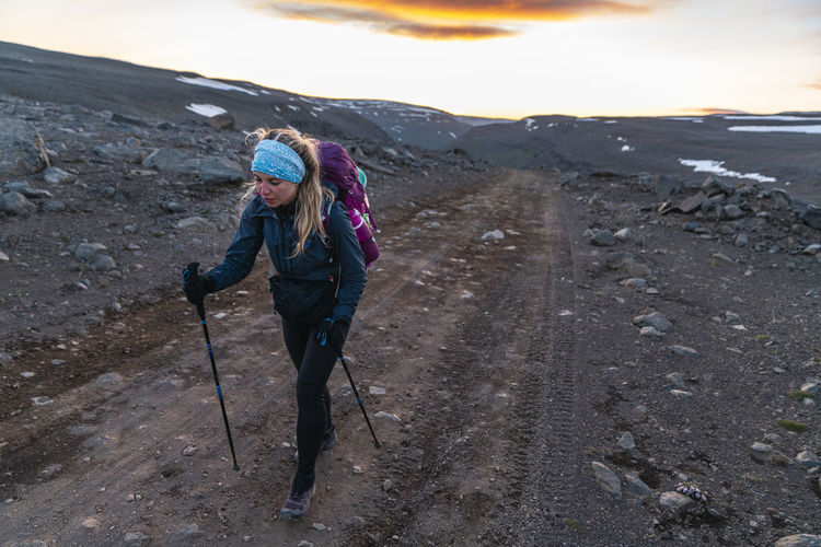 Female hiker on dirt road to highlands in remote iceland wilderness