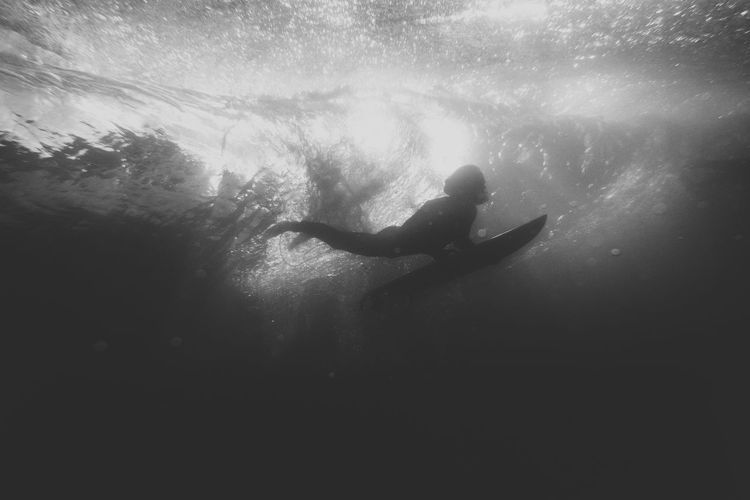 Silhouette man swimming in sea