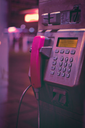 Vertical closeup shot of a public public phone booth with pink handset in duisburg, germany