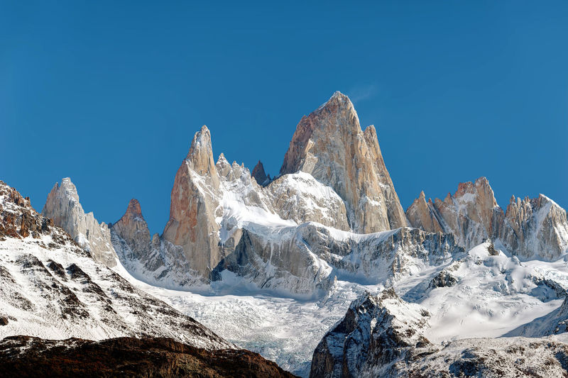 Scenic view of snowcapped mountains against clear blue sky