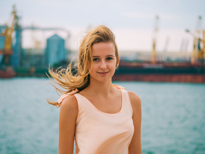 Portrait of beautiful woman standing at harbor