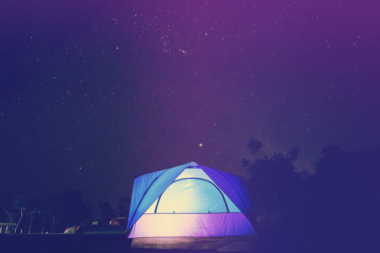Tent against blue sky at night
