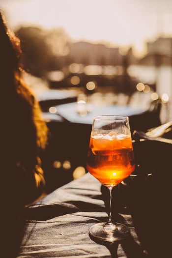 Close-up of beer glass on table against sky during sunset