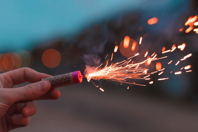 Cropped image of hand holding firework