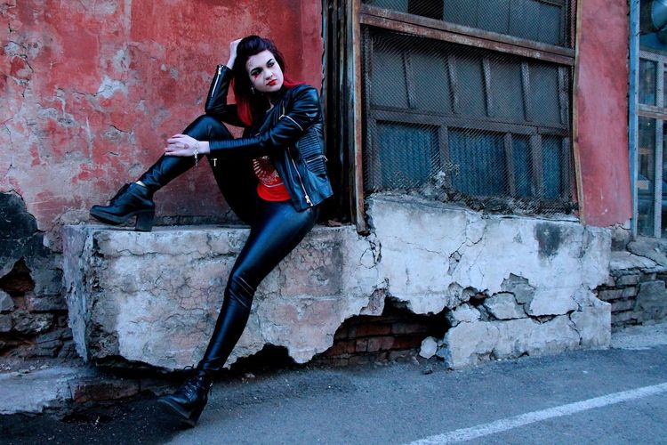 Portrait of punk woman by abandoned building
