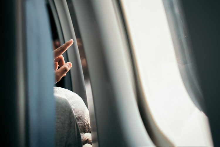 Close-up of woman pointing in airplane