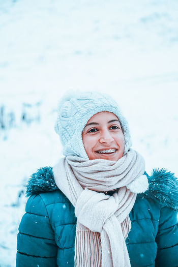Close-up of smiling woman looking away during winter