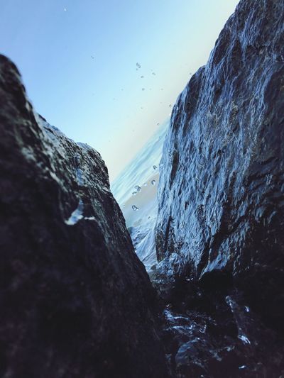 Close-up of rock by sea against sky