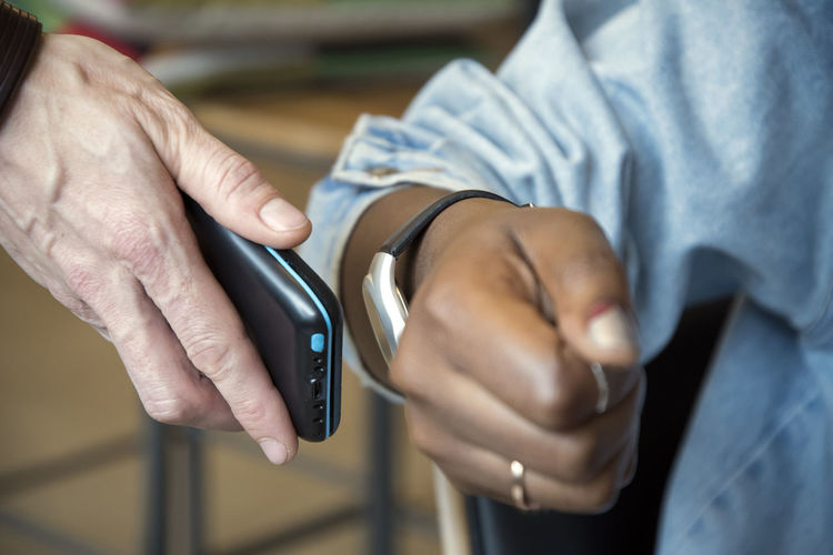 Woman paying with smartwatch and nfc reader